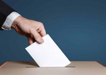 Voter Holds Envelope In Hand Above Vote Ballot. Freedom Democracy Concept