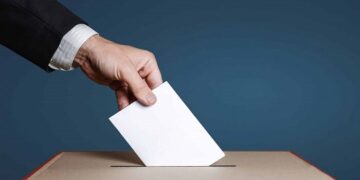 Voter Holds Envelope In Hand Above Vote Ballot. Freedom Democracy Concept