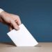 Voter Holds Envelope In Hand Above Vote Ballot. Freedom Democracy Concept